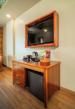 A kitchenette with a built-in oven, a coffee maker, a kettle, and a small refrigerator.