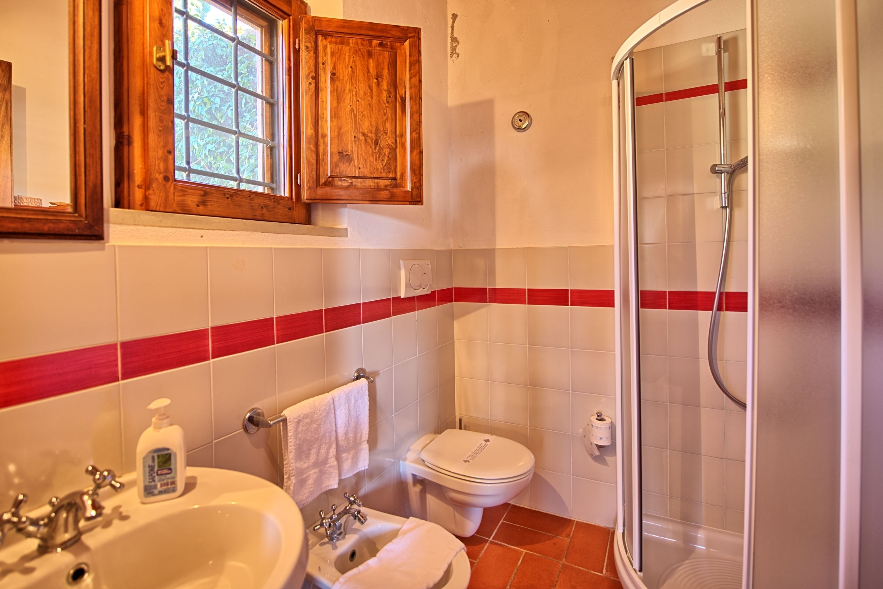 Une salle de bain équipée d’un lavabo, de toilettes et d’une douche à parois en verre.