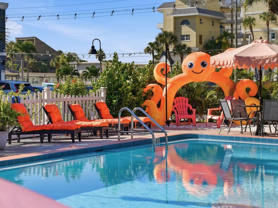 A swimming pool with lounge chairs and inflatable decorations.