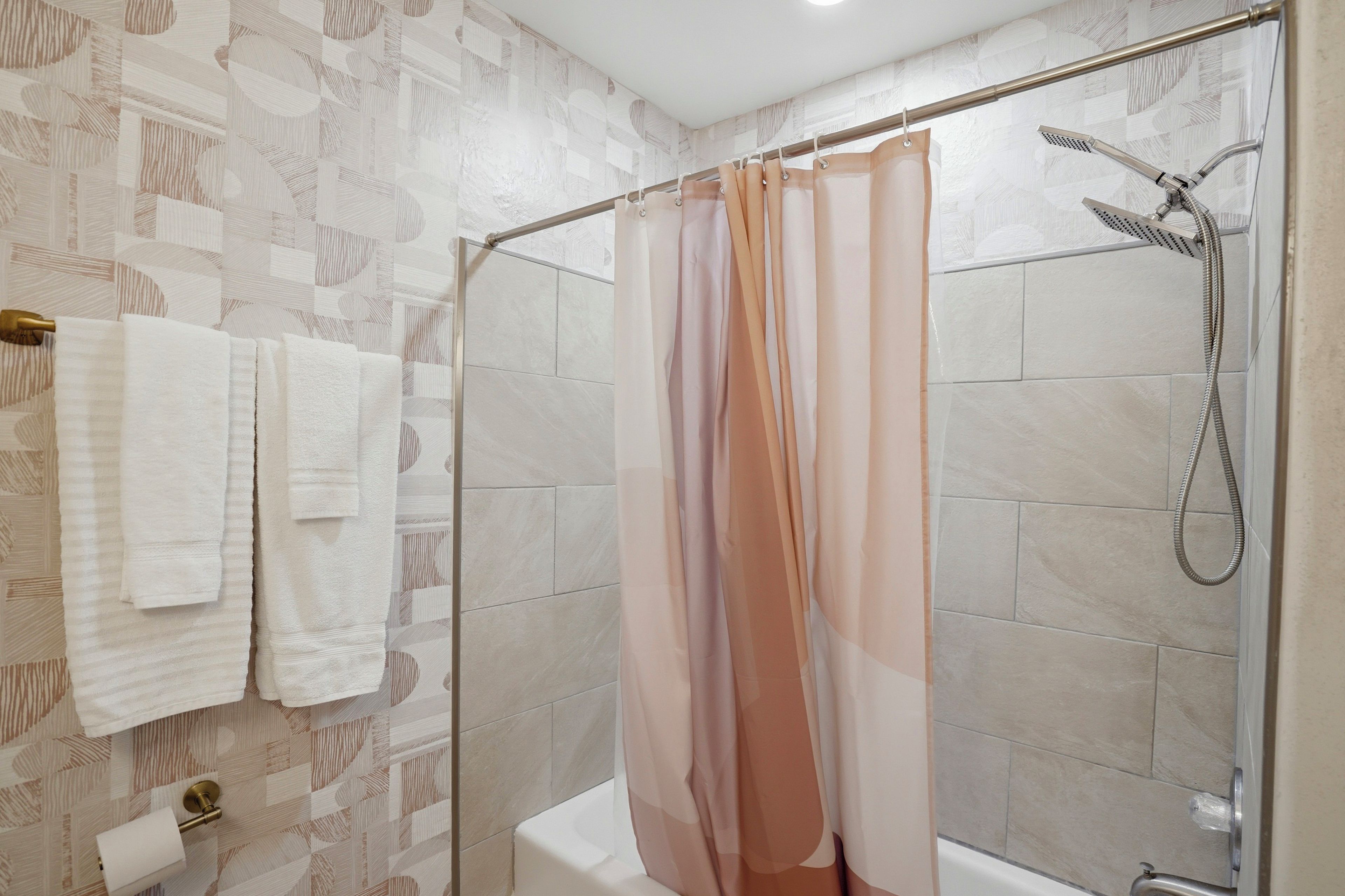 Un bagno con doccia, WC e porta asciugamani.