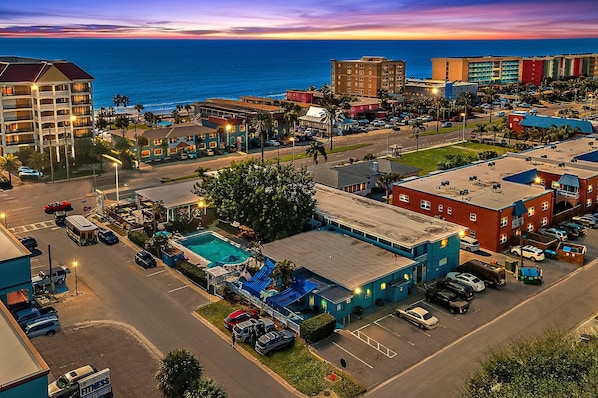 A hotel with multiple floors, a swimming pool, and a parking lot. - Malibu Resort Motel (North Redington Beach)