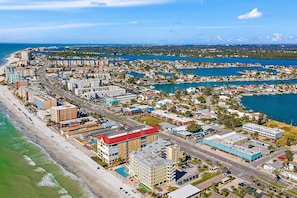An aerial view of a coastal city with a beachfront hotel, roads, and water bodies. - Malibu Resort Motel (North Redington Beach)