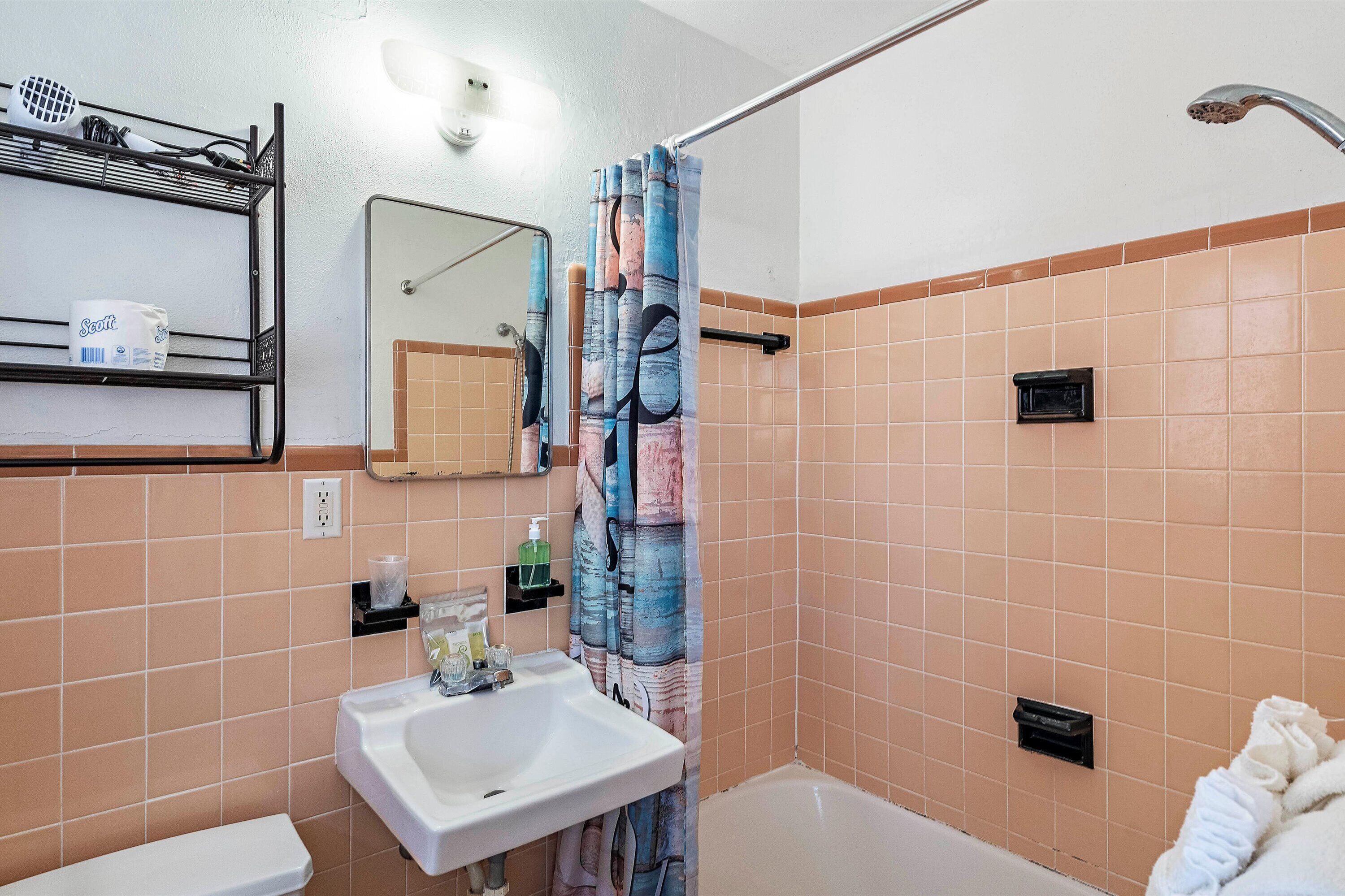 A bathroom with a sink, toilet, and shower area.