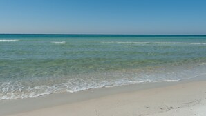 A beach with clear water and a sandy shore. - Gulf Crest Condominiums (Panama City Beach)