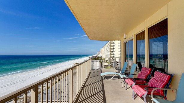 A balcony with a view of the beach and ocean, featuring several chairs and a table. - Gulf Crest Condominiums (Panama City Beach)