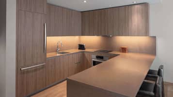 A modern kitchen with wooden cabinetry, a stainless steel sink, and a built-in oven.