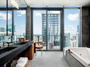 A modern bathroom with a large bathtub, a vanity with a sink, and a chair.