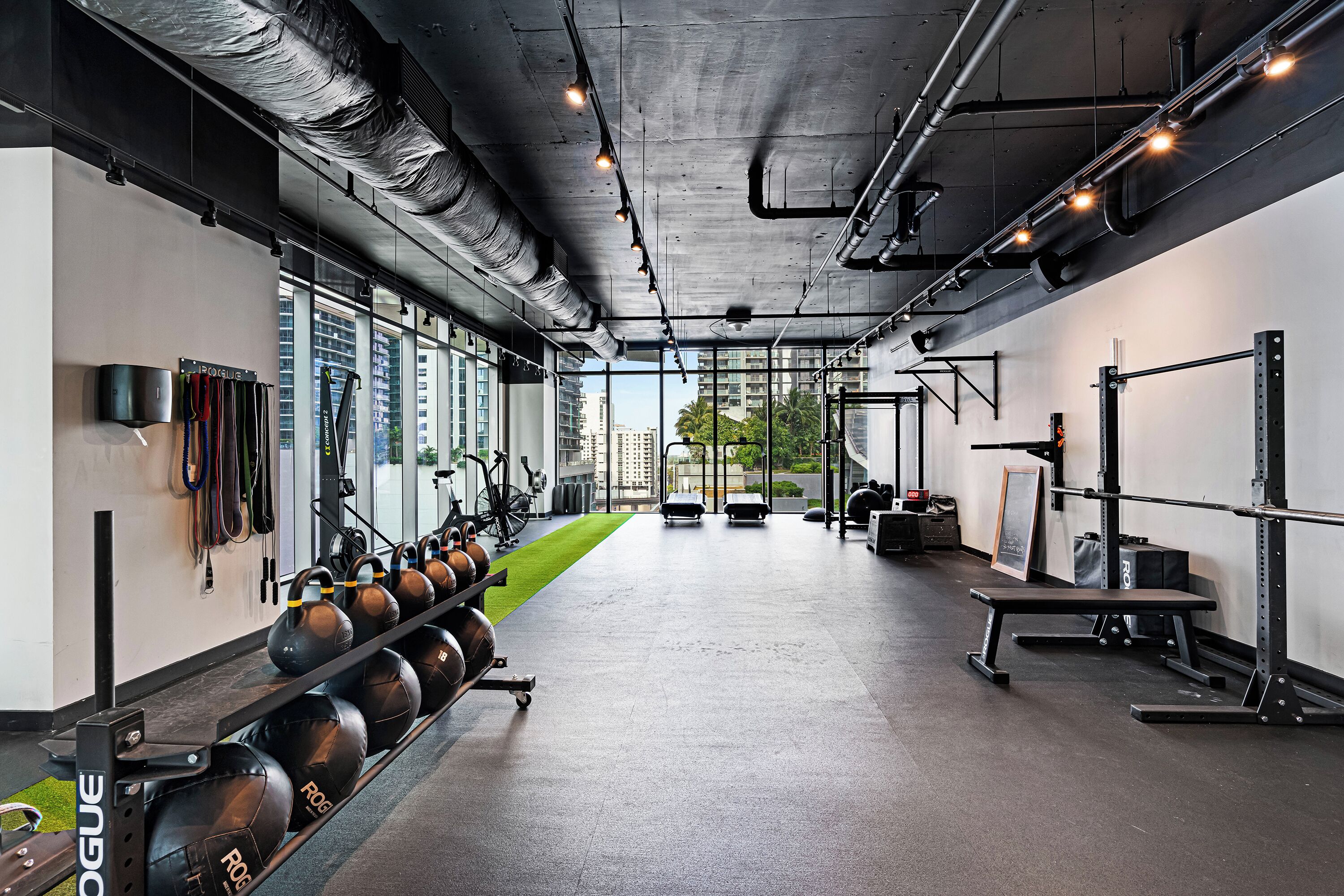 A gym with exercise equipment, a bench, and a weight rack.
