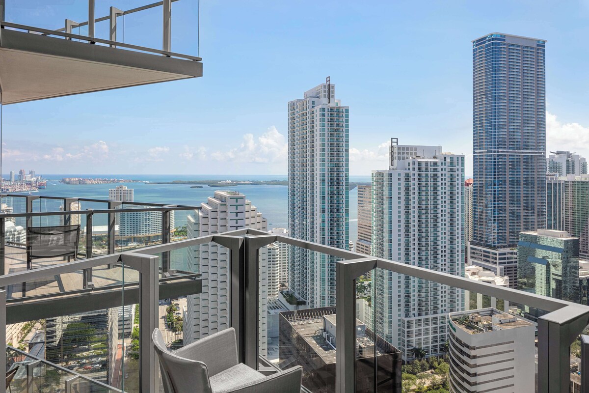 Un edificio alto con vistas al horizonte de la ciudad y una masa de agua al fondo.