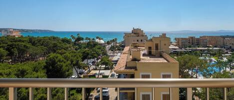 A coastal view with buildings, a clear sky, and a beach.