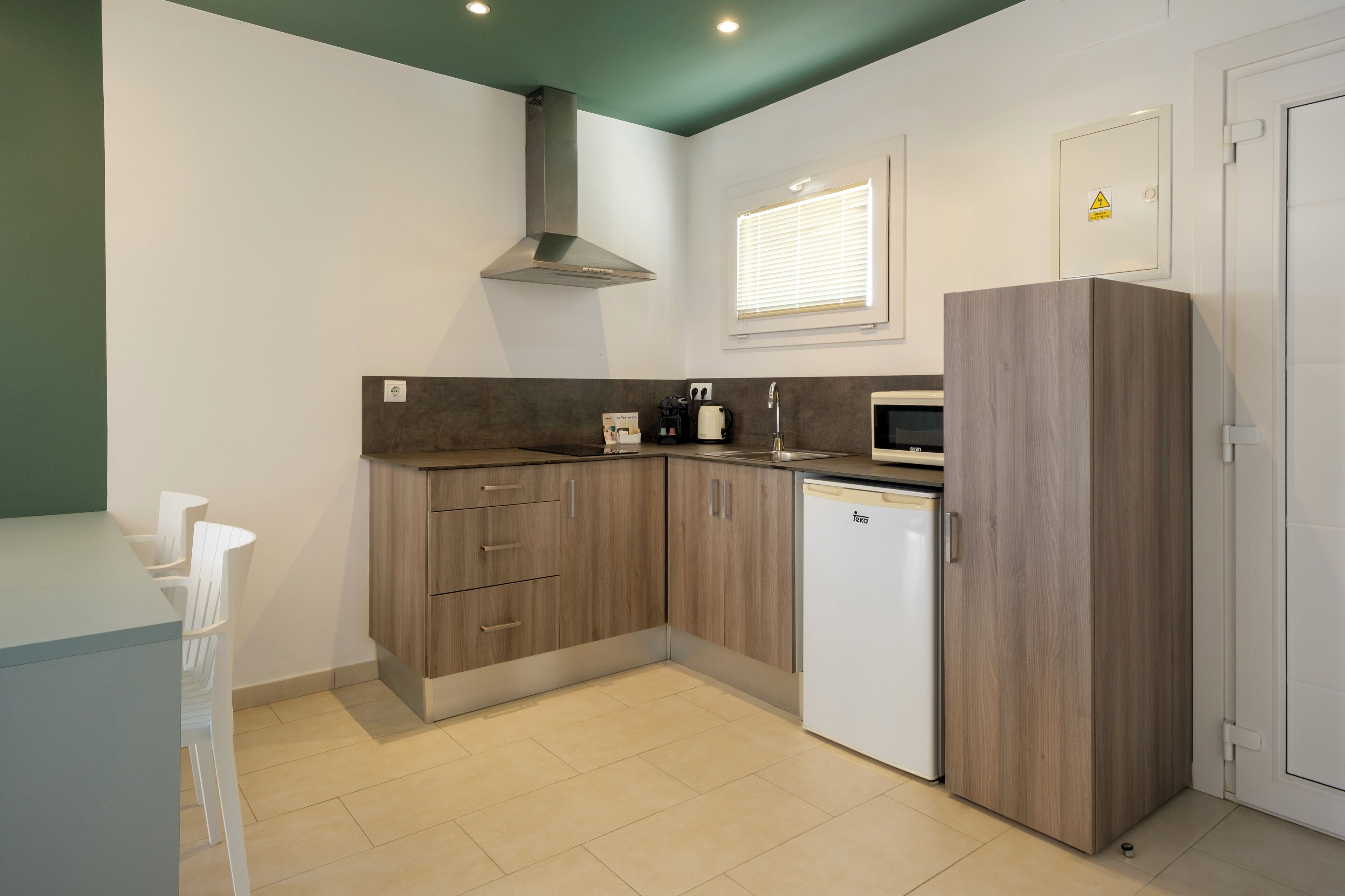 A compact kitchen with wooden cabinets, a built-in microwave, and a dishwasher.