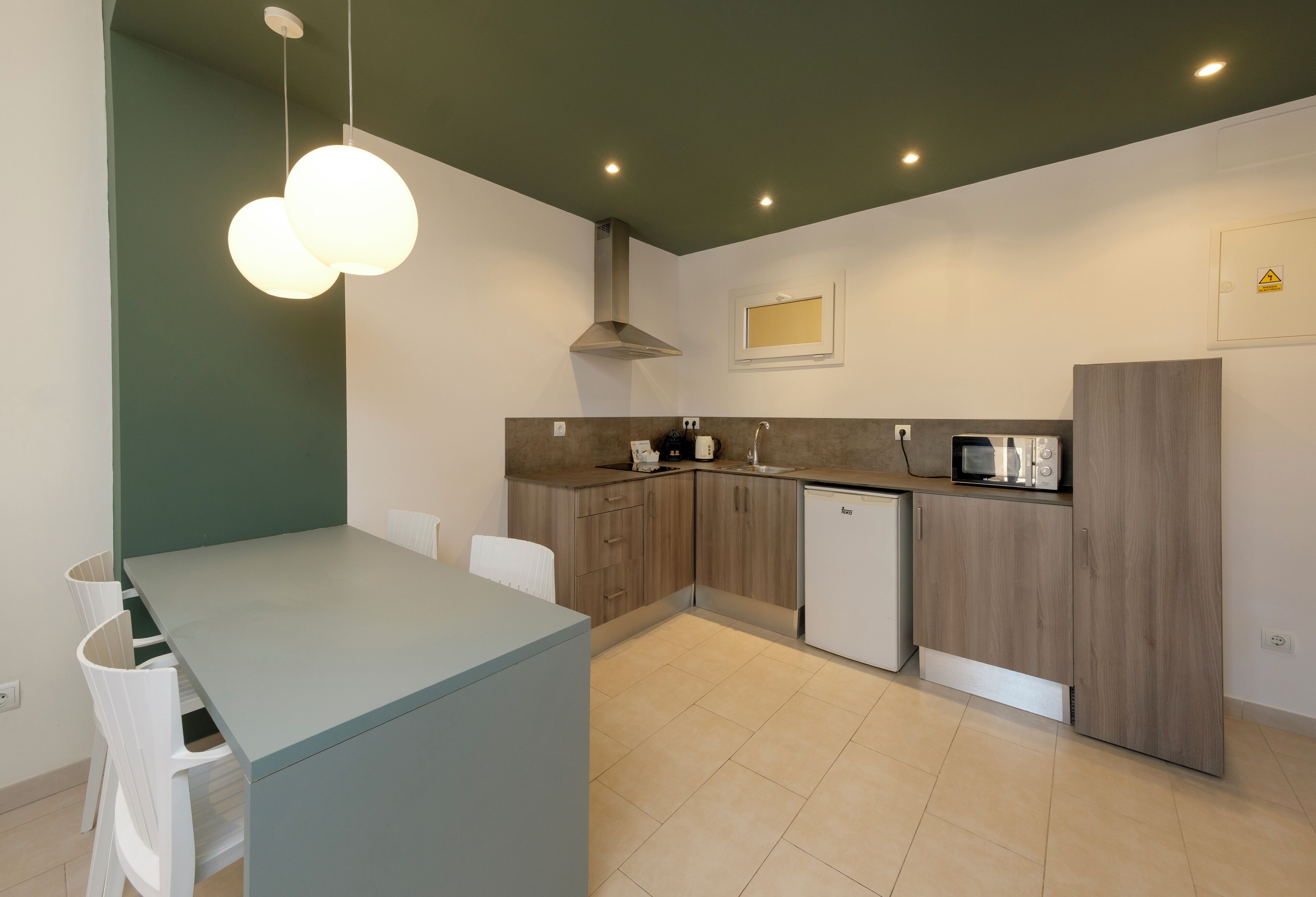 Una cocina moderna con una isla central, armarios de madera, microondas y horno empotrado.