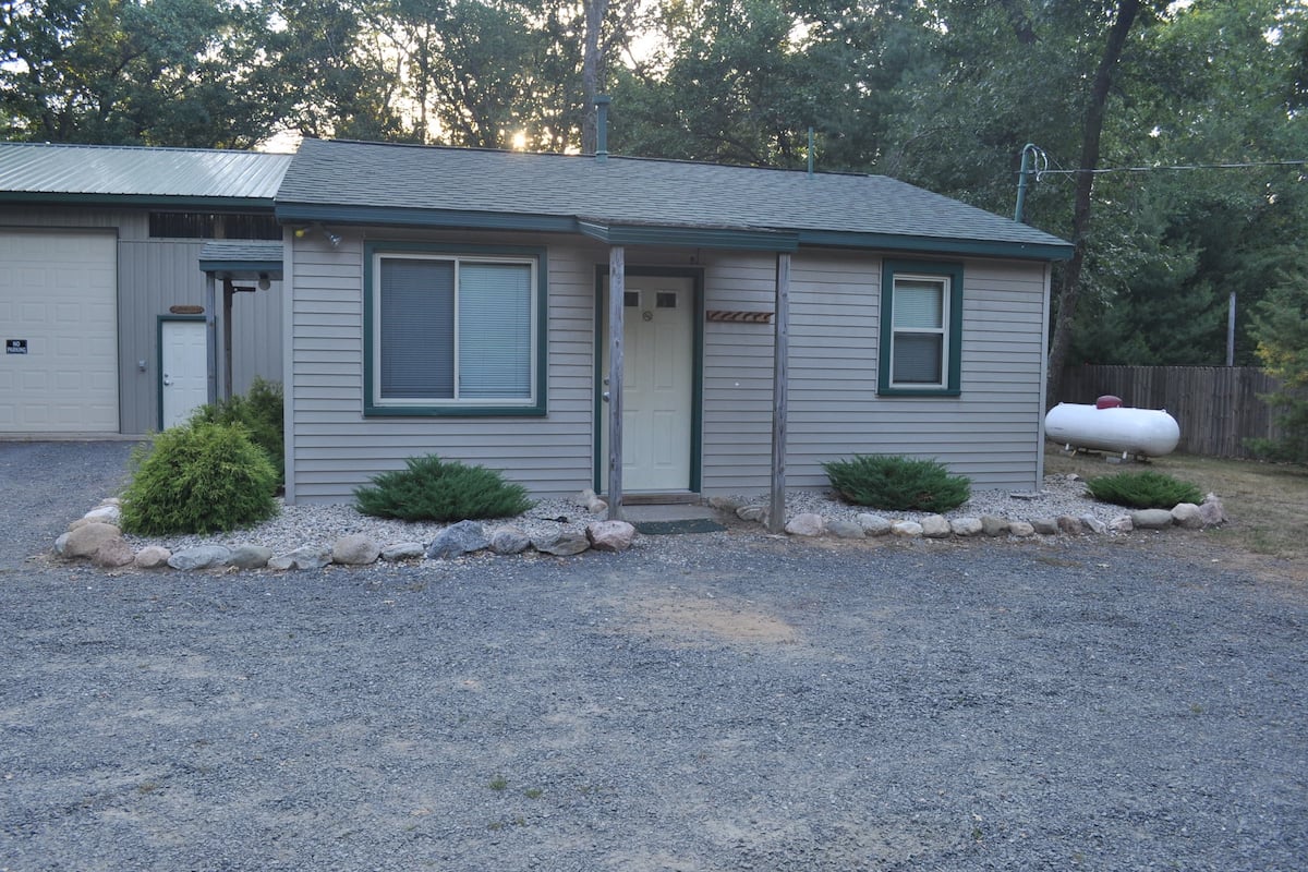 A single-story house with a front door, two windows, and a garage.