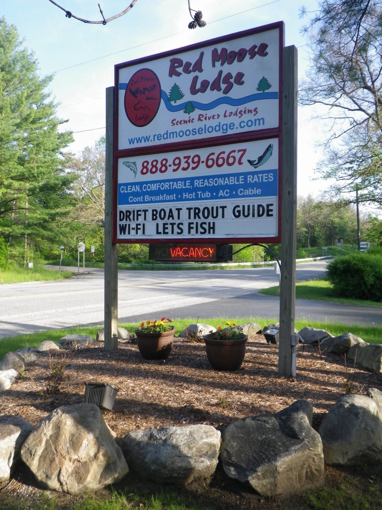 A Red Moose Lodge sign with contact information and amenities listed.