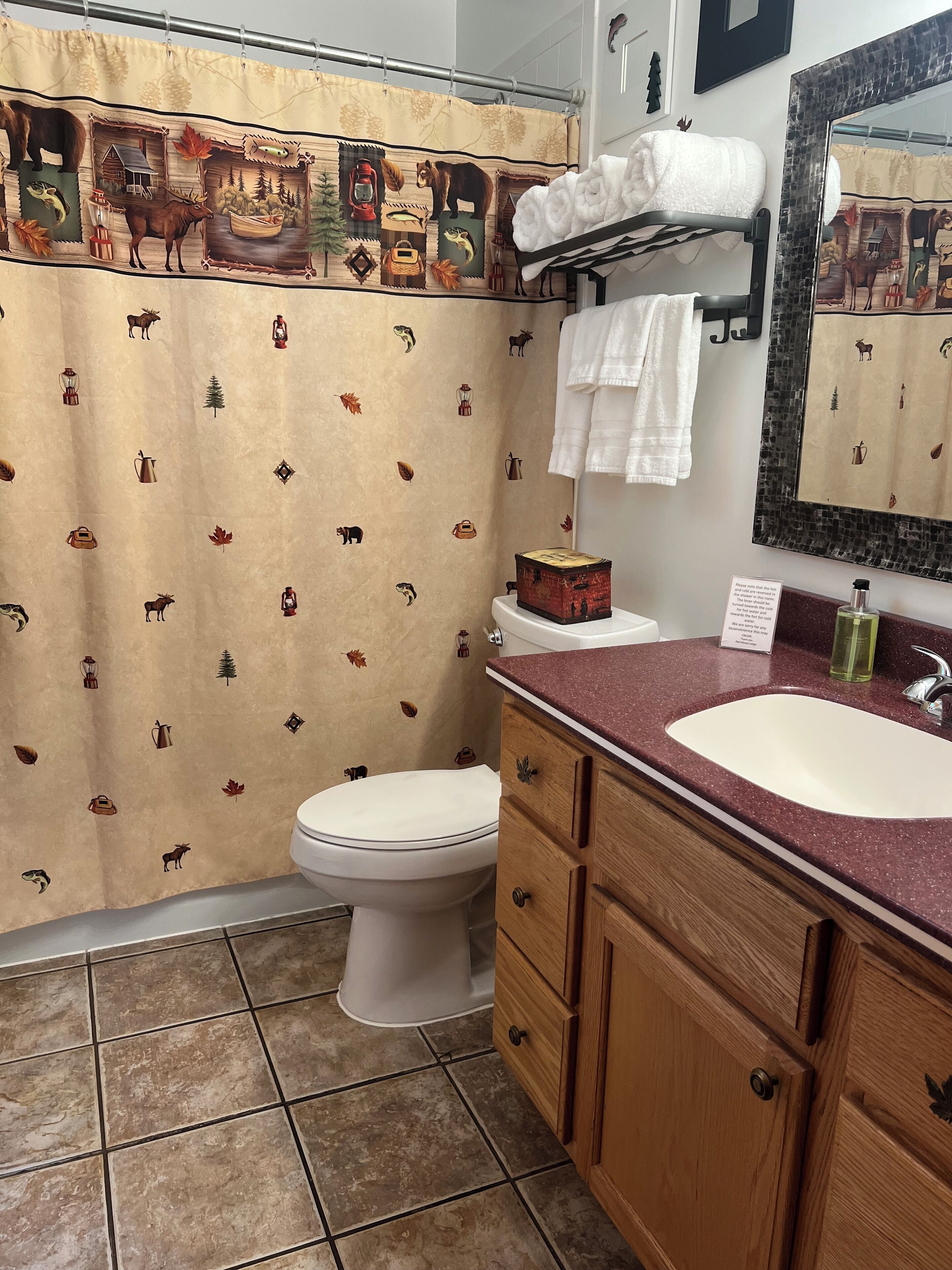 Un baño con temática rústica, que incluye inodoro, lavamanos y armarios de madera.