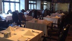 A restaurant with multiple tables set for dining, featuring white tablecloths and basic table settings. - Auberge du Tresor (Québec City)