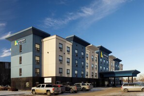 Un hôtel à plusieurs étages au design moderne, avec une enseigne bien visible indiquant « Home Inn & Suites ».
