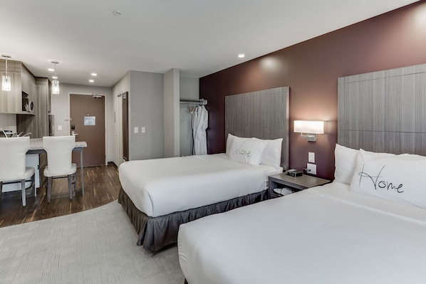 A hotel room with two beds, a desk, and a chair. - Home Inn & Suites Saskatoon South (Saskatoon)