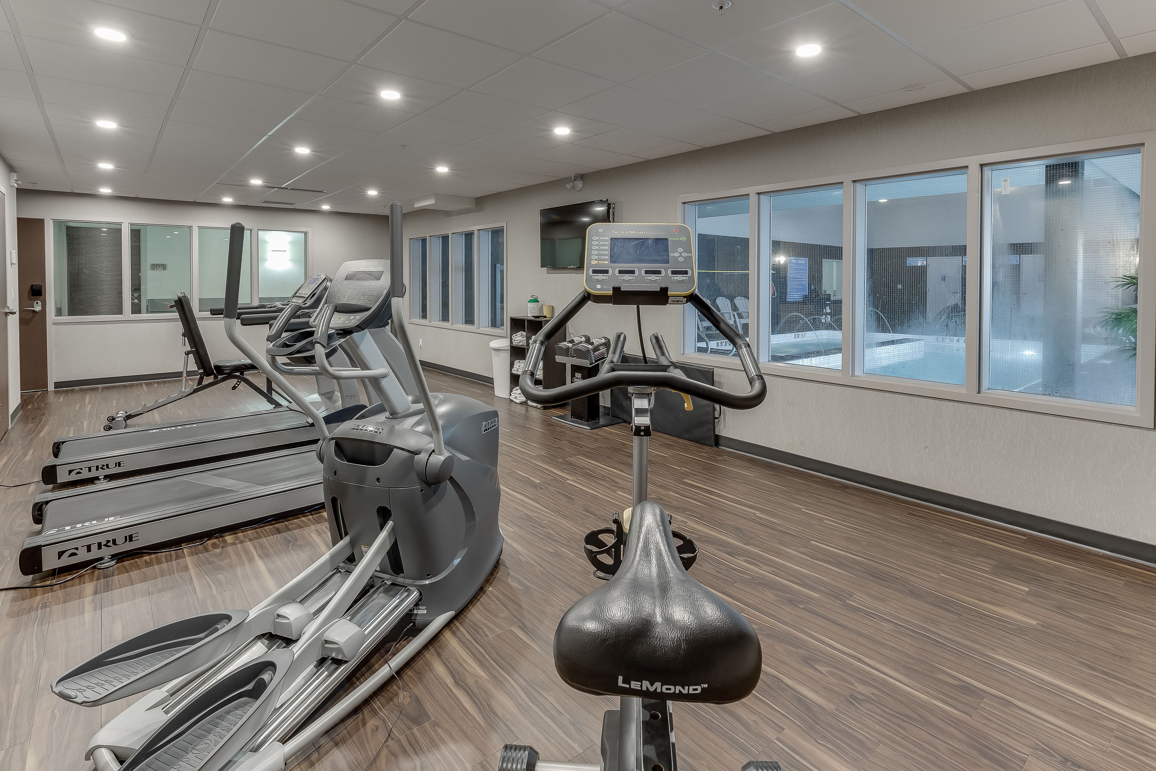 A gym with treadmills, ellipticals, and a stationary bike.