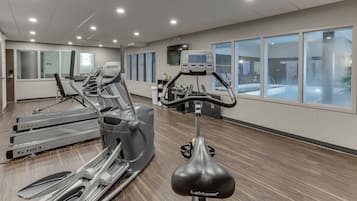 A gym with treadmills, ellipticals, and a stationary bike.