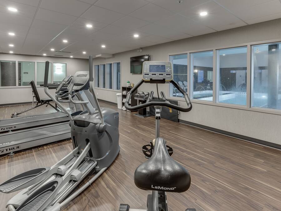 A gym with treadmills, ellipticals, and a stationary bike.