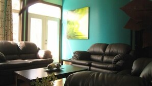 Un soggiorno con due divani in pelle, un tavolino da caffè e un quadro appeso alla parete.