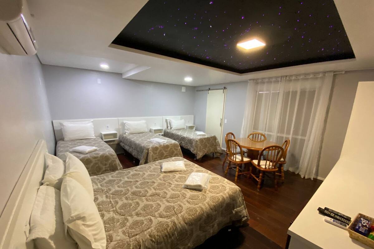 Ein Hotelzimmer mit zwei Betten, einem Esstisch und einer Decke mit Sternenmuster.