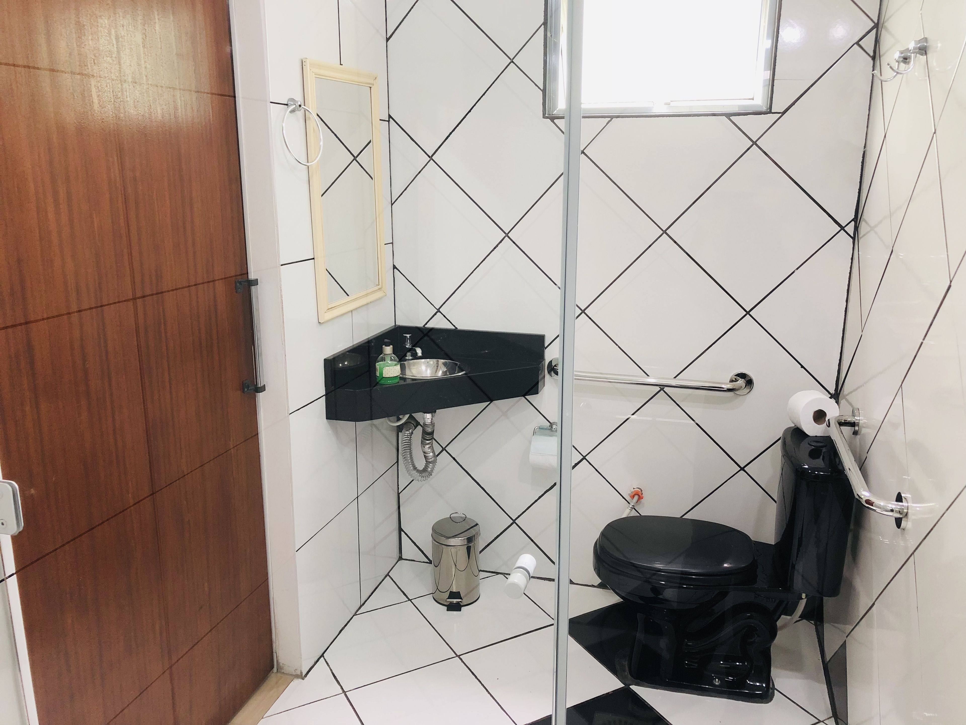 A bathroom with a black sink, a toilet, and a mirror.