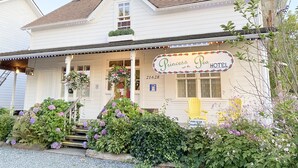 A white building with a sign reading "Princess Pea Hotel." - Princess and the Pea Hotel (Langley)