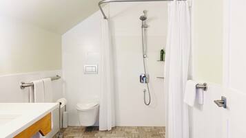 Un baño moderno con ducha, inodoro y lavamanos.