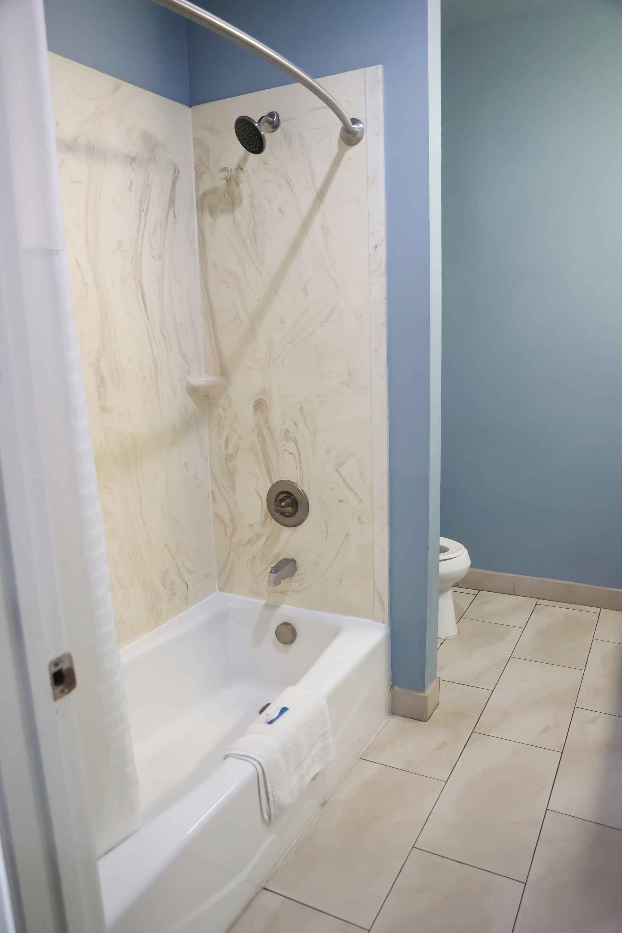 A bathroom with a shower, a toilet, and a bathtub.