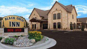 A building labeled "Black Gold Inn" with a stone facade and a sign indicating it is now open. - Black Gold Inn (Yoakum)