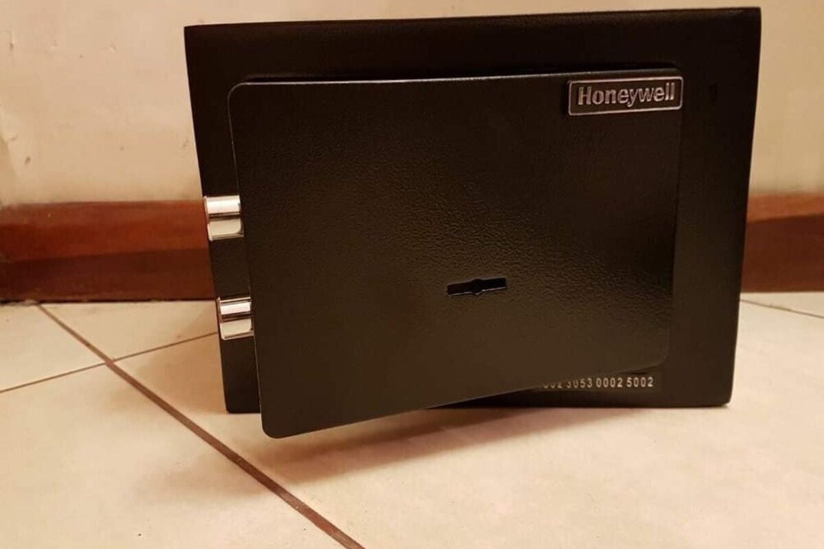 A black Honeywell thermostat on a tiled floor.