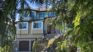 A two-story house with a stone facade, a garage, and a well-maintained garden.