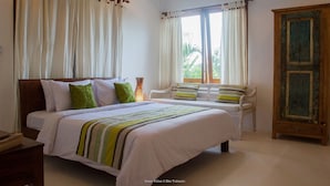 Un dormitorio con cama, un armario de madera y una ventana con cortinas.