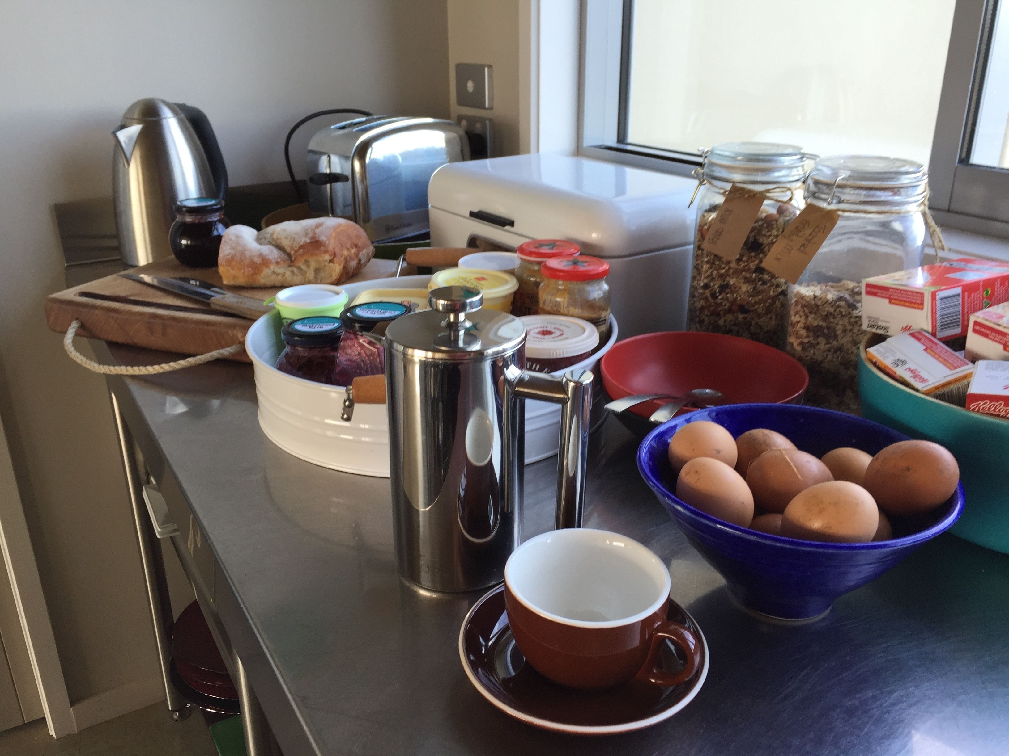A kitchen counter with various breakfast items, including eggs, bread, and condiments.