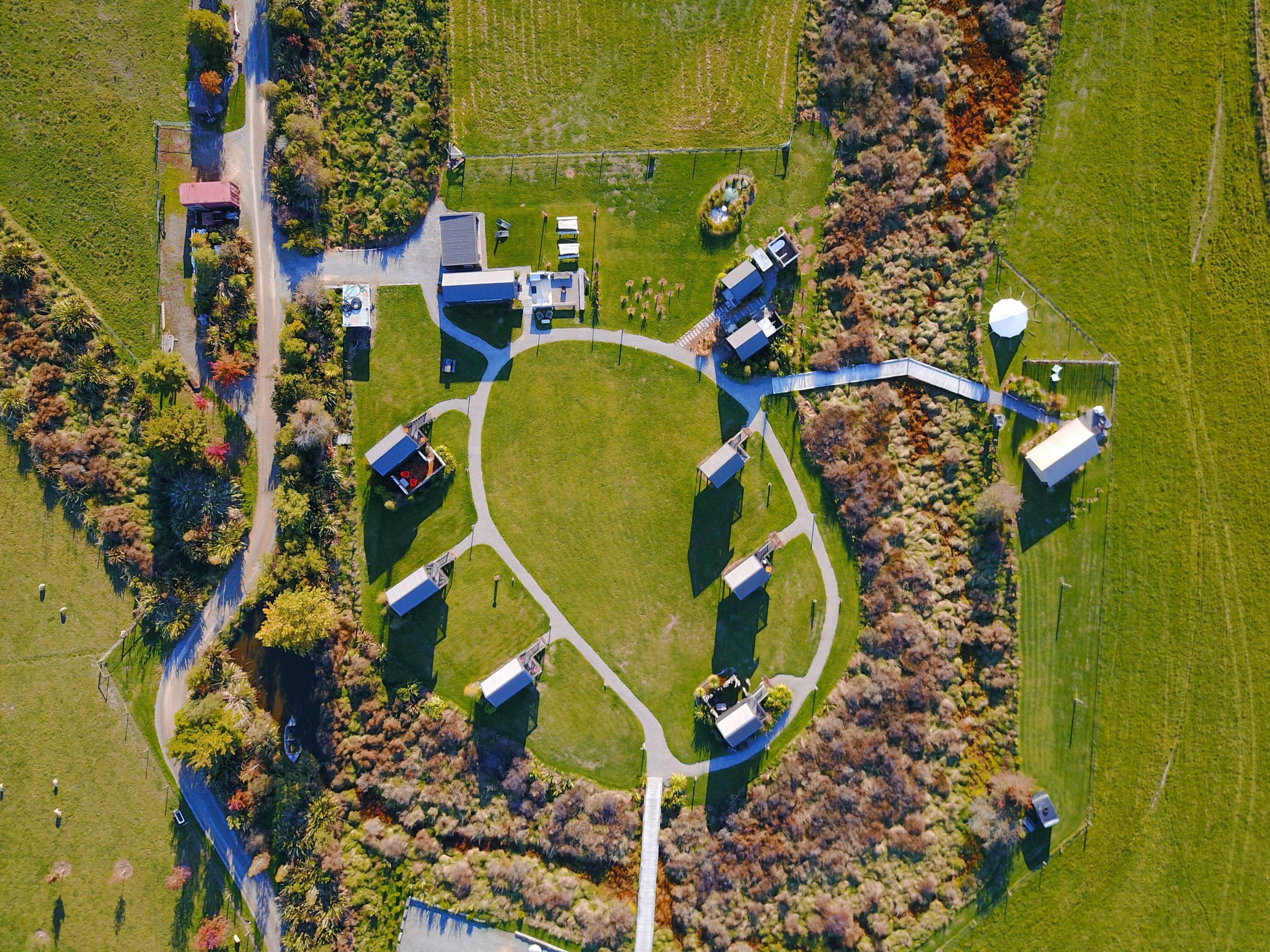 An aerial view of a property with a central circular lawn, surrounded by buildings and pathways.