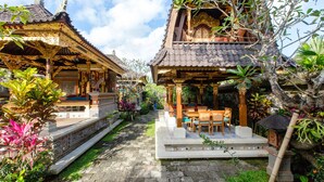 Un tradizionale tempio balinese con architettura elaborata, un cortile centrale e una rigogliosa vegetazione circostante.