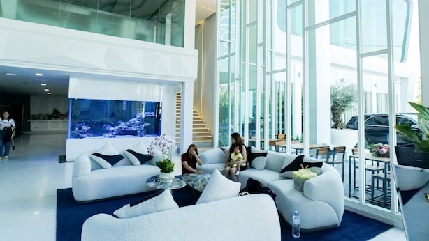 A spacious lobby with a large aquarium, modern furniture, and large windows offering views of the outdoors. - Glacier Hotel Khon Kaen (Khon Kaen)