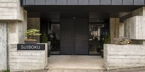 A modern building entrance with a sign reading "SUIBOKU". - Suiboku (Kutchan)