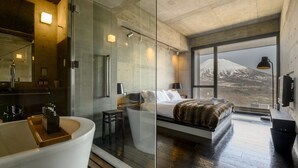 Ein modernes Badezimmer mit einer Badewanne, einem großen Spiegel und einer Duschkabine aus Glas.