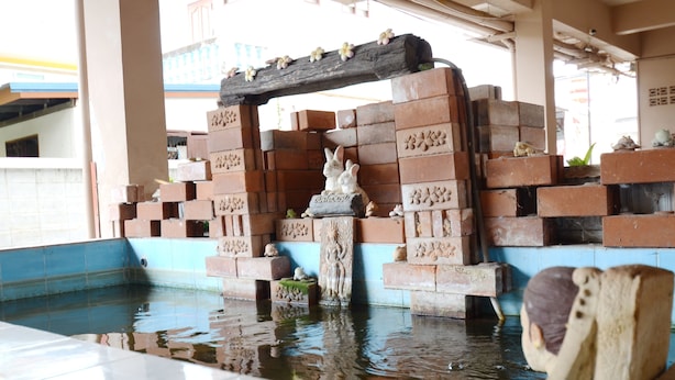 A pool with a brick structure and a statue of a rabbit. - DMa Hotel (Khon Kaen)