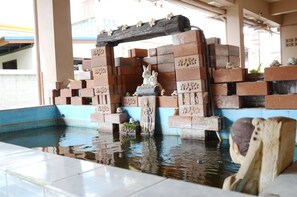 Ein Pool mit einer Ziegelstruktur und einer Kaninchenstatue.