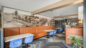 Un restaurant doté d’un long comptoir, d’un espace pour s’asseoir et d’une fresque murale.