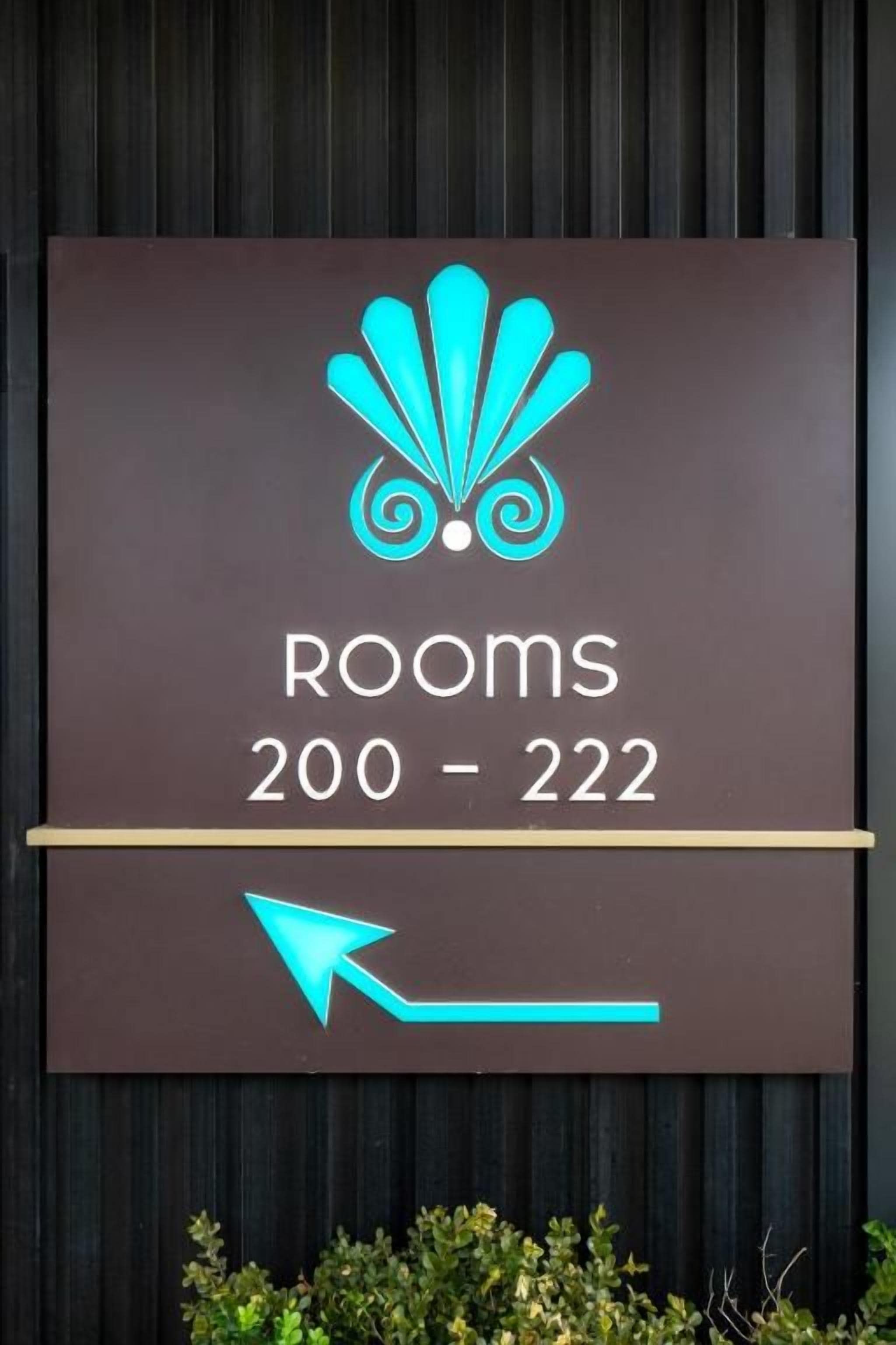 Un panneau indiquant les numéros de chambre 200 à 222, avec une flèche indiquant la direction.