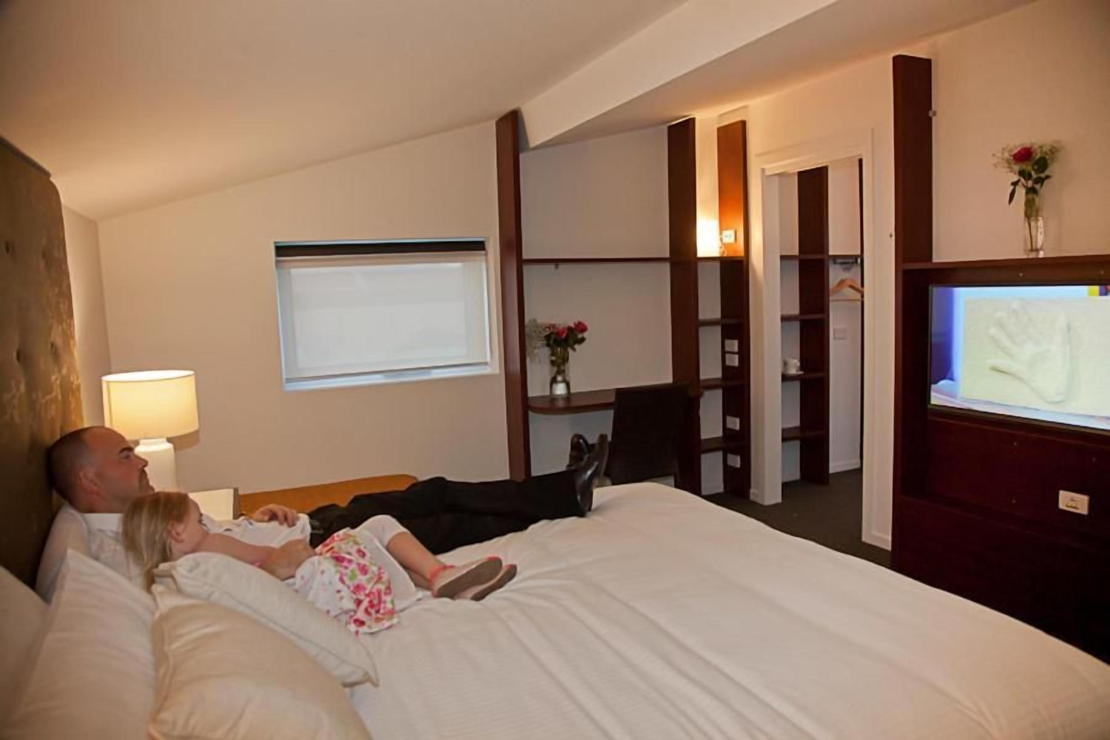Une chambre d’hôtel avec un lit, une télévision, un bureau et une chaise.