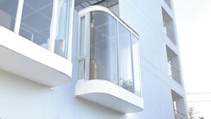 A modern building with a curved balcony and large windows. - Rua Rasada Express (Trang)