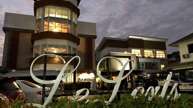 Un hotel con una torre destacada y un cartel iluminado grande.