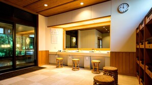 A modern interior with a wooden ceiling, a large mirror, three wicker stools, and a clock on the wall. - Lectore Atami Koarashi (TKP Hotels & Resorts) (Atami)
