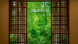 A room with a view through a wooden lattice window, revealing dense green foliage outside. - TKP Hotel & Resort Lectore Hakone Gora (Hakone)